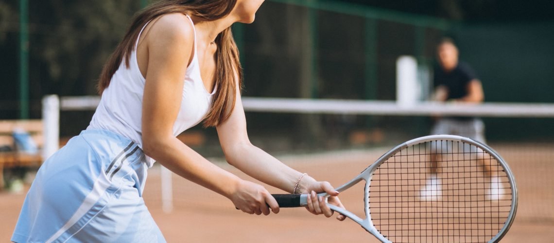 Young woman playing tennis at the court